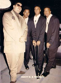 a group of men standing next to each other wearing suits and holding umbrellas in their hands