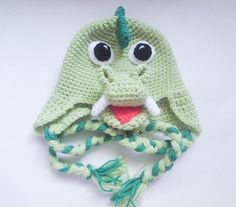 a crocheted green hat with eyes and a braid around it's brim