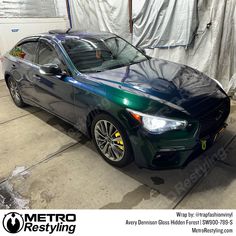 a green car parked in a garage next to a tarp covered wall with the words metro restying on it