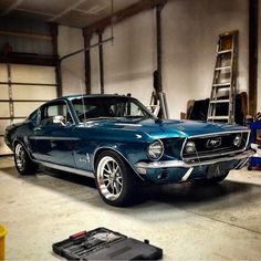 an old blue mustang in a garage