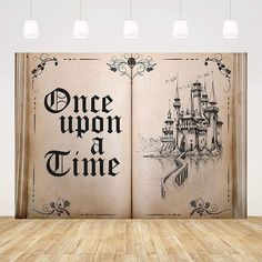 an open book with the words once upon a time on it in front of a wooden floor