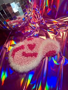 a disco ball with a smiley face on it next to a pink fuzzy rug and mirror balls