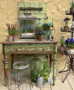 an old green table with some plants on it