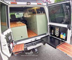 the interior of an rv with wood flooring and storage compartments on the back door