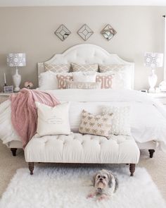 a white bed sitting in a bedroom next to a window