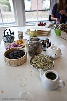 the table is full of spices and condiments, including teapots and bowls