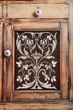 an old wooden cabinet with decorative carvings on the door and drawer knobs inlayed to it