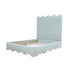 a white bed frame with scalloped edges and no headboard or foot board