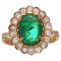 Zambian Cabochon Emerald and Diamond 18kt Gold Cluster Ring. Elevate your style with this stunning Zambian Emerald and Diamond Cluster Ring, a masterpiece of elegance and sophistication. Crafted from exquisite 18kt yellow and white gold, this ring features a dazzling oval faceted Zambian emerald as its centrepiece. Surrounding the emerald are 26 round brilliant-cut diamonds. Specifications: Finger Size: UK: N EU: 55 US: 7 Ring Dimensions: 2.7 x 2 x 1.7 cm Weight: 6.00 grams Emerald Details: Origin: Zambia Cut: Oval faceted Quantity: 1 Total Carat Weight: 4.63 carats Treatment: Natural Diamond Details: Cut: Round Brilliant Quantity: 26 Total Carat Weight: 0.90 carats Colour: F - G Clarity: SI1 Condition: The ring is pre - owned, excellent condition overall. 7 Ring, Zambian Emerald, Diamond Cluster Ring, Zambia, Diamond Cluster, Emerald Diamond, Round Brilliant Cut Diamond, Cluster Ring, Round Brilliant Cut