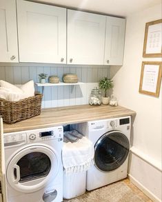 a washer and dryer in a small room with white cabinets on the wall