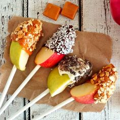 four apples on sticks with nuts and caramel