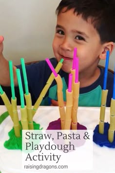 a young boy sitting at a table with plastic straws and playdough activity