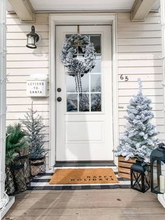 a front door decorated for christmas with wreaths and evergreen trees