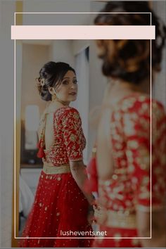 a woman standing in front of a mirror wearing a red dress