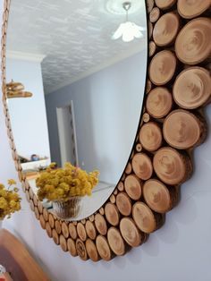 a mirror hanging on the side of a wall next to a vase filled with flowers