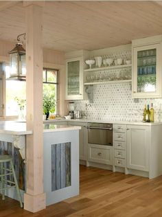 a kitchen with wooden floors and white cabinets