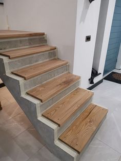 a set of stairs made out of concrete with wood treads and handrails