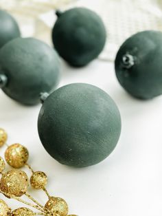 some green and gold ornaments on a white table