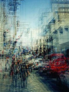 blurry photograph of people walking down the street in front of cars and telephone poles