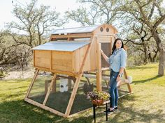 a woman standing next to a chicken coop