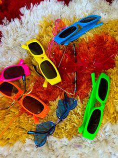 four pairs of sunglasses laying on a rug