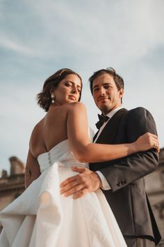 a bride and groom embracing each other outside