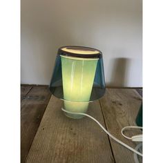 a lamp that is sitting on top of a wooden table next to a light bulb