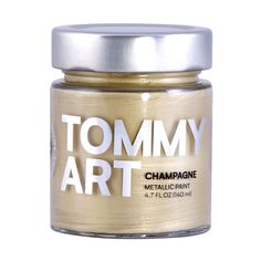 a jar of gold metallic paint with the words tommy art on it's lid