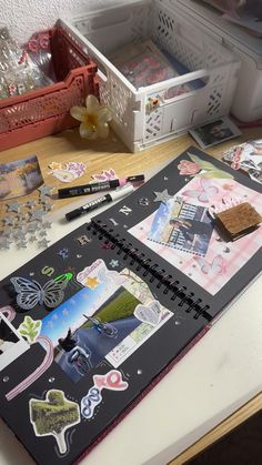 an open notebook sitting on top of a table covered in stickers and other items