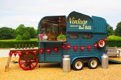 an old fashioned food truck is parked in the gravel