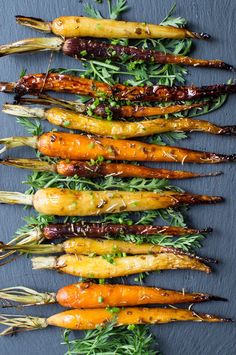 carrots with herbs and seasoning on a slate board, ready to be cooked