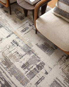 a living room area with two chairs and a rug on the floor in front of them