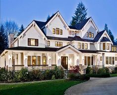 a large white house with lots of windows on it's sides and front porch