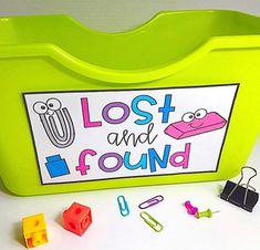 a green plastic box filled with lots of magnets next to some clips and paper clips