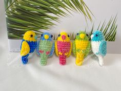 small crocheted parrots are lined up in a row