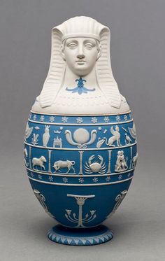 a blue and white vase with an egyptian head on it