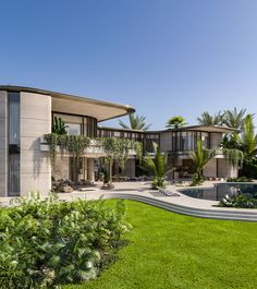 a modern house surrounded by greenery and palm trees