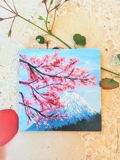 a painting of a cherry blossom tree with a mountain in the background and red petals