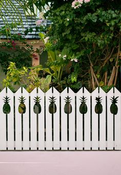 a white fence with pineapples painted on it