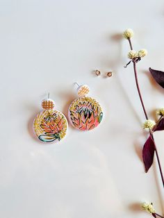 Add a pop of color and playfulness to any outfit with our Handpainted Protea Earrings. These unique earrings feature a fun design on the back and come in two options: with or without black accents. Made with high quality 925 silver stud posts and handcrafted from durable polymer clay. Hand Painted Drop Earrings For Everyday, Playful Hand Painted Dangle Jewelry, Hand Painted Artsy Earrings For Everyday, Unique Hand Painted Everyday Earrings, Artsy Hand Painted Earrings For Everyday, Unique Hand Painted Earrings For Everyday, Unique Hand Painted Earrings For Everyday Wear, Everyday Hand Painted Artsy Earrings, Artsy Hand Painted Everyday Earrings