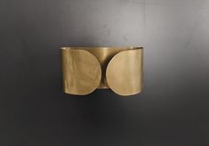 a gold metal object on a black wall