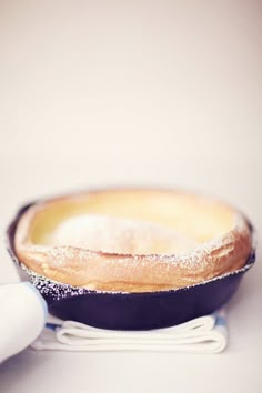 a skillet with powdered sugar in it sitting on top of a white table