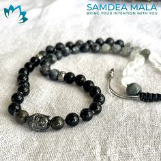 MEZZO MALA E BRACCIALE TRE GIRI
 
OSSIDIANA, LABRADORITE, SELENITE e meru in OCCHIO DI FALCO con BUDDHA IN ACCIAIO

 Questo mala può essere indossato al collo o al polso sinistro, come da tradizione.

 Tradizionalmente un mala è composto da 108 pietre, ma può anche essere più corto; la regola importante da seguire è che i grani siano multipli di nove.
 Un mala corto con pietre da 8 mm permette un facile conteggio durante la meditazione ed è anche meno impegnativo da indossare poiché è più corto Spiritual Obsidian Beaded Bracelets With Natural Stones, Spiritual Labradorite Beaded Bracelets As Gift, Adjustable Hand Wrapped Mala For Healing, Adjustable Spiritual Obsidian Jewelry, Black Moonstone Spiritual Jewelry, Spiritual Black Moonstone Jewelry, Silver Adjustable Spiritual Mala, Adjustable Silver Spiritual Mala, Adjustable Silver Mala For Meditation