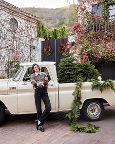 a woman standing next to a white truck with christmas decorations on the front and side