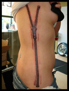 a woman's back with a zipper tattoo on her stomach and an armband