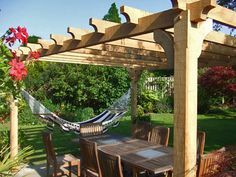 an outdoor dining area with hammock and chairs