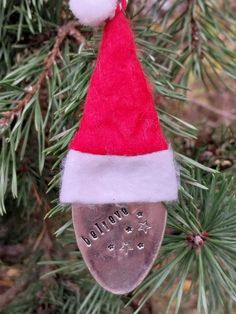 a christmas ornament hanging from a tree with a santa's hat on it