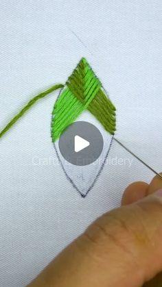 someone is stitching something with green thread