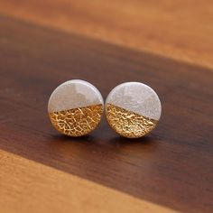 pair of gold and white earrings on wooden surface