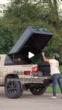 a man standing next to a truck with its hood open